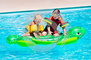 Kids in swimming pool with inflatable toy