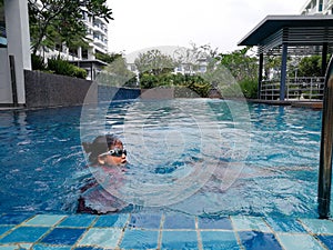 Kids swimming at the swimming pool.