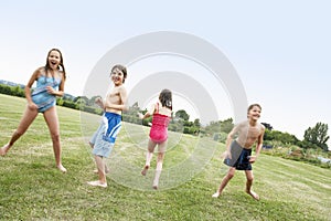 Kids In Swimsuits Playing On Field