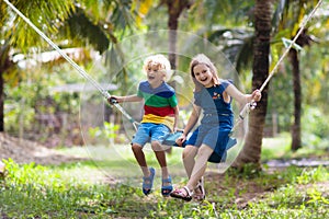 Kids on swing. Playground in tropical resort