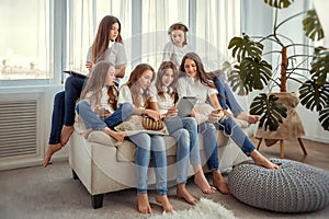 Kids with tablet pc computer communicate in social networks. Group of teenage girls is using gadgets.