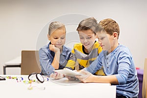 Kids with tablet pc programming at robotics school