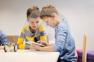 Kids with tablet pc programming at robotics school