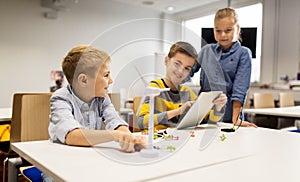 Kids with tablet pc programming at robotics school