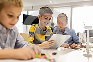 Kids with tablet pc programming at robotics school