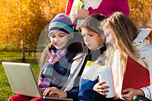 Kids talking with laptop outside