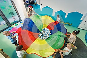 kids and teacher holding a piece with balls on it, nursery, creative activities for preschoolers