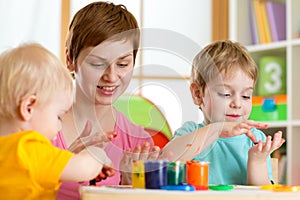 Kids with teacher painting in playschool photo