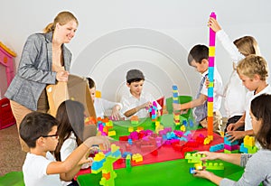 Kids with teacher playing with building blocks
