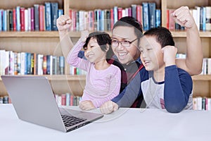 Kids and teacher raise hands in library