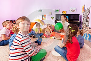 Kids and teacher sit in circle