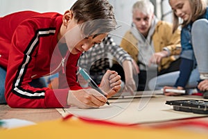 Kids with teacher working together on project with electric toys and robots at robotics classroom