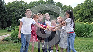 Kids team building. A group of happy children holding hands together. Team outdoor in park