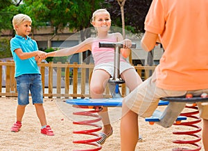 kids are teetering on the swing on the playground. photo