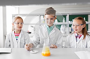 Kids with test tube studying chemistry at school
