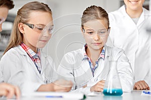 Kids with test tube studying chemistry at school