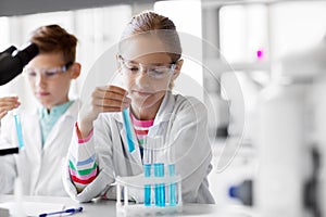 Kids with test tubes studying chemistry at school