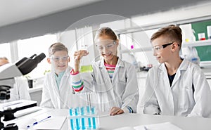 Kids with test tubes studying chemistry at school