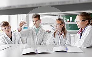 Kids with test tubes studying chemistry at school