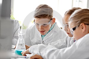 Kids with test tubes studying chemistry at school