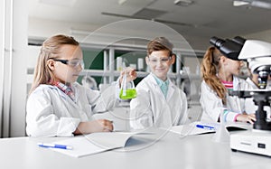 Kids with test tubes studying chemistry at school