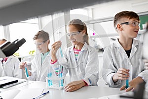 Kids with test tubes studying chemistry at school