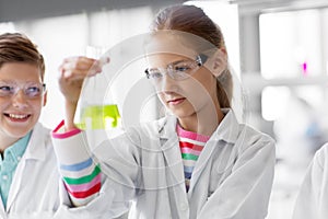 Kids with test tubes studying chemistry at school