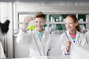 Kids with test tubes studying chemistry at school