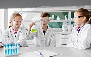 Kids with test tubes studying chemistry at school