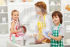 Kids and their mother washing dishes