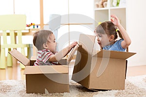 Kids in their new home having fun with cardboard boxes