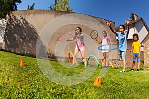 Kids throw hula hoops to target, competitive game