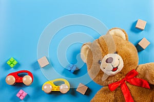 Kids toys background with teddy bear, wooden cars, construction blocks and cubes