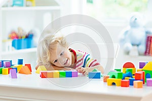 Kids toys. Child building tower of toy blocks