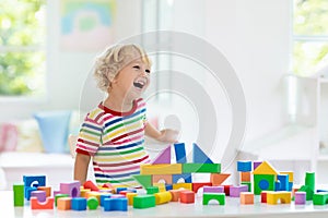 Kids toys. Child building tower of toy blocks
