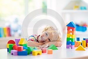 Kids toys. Child building tower of toy blocks
