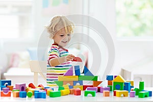 Kids toys. Child building tower of toy blocks