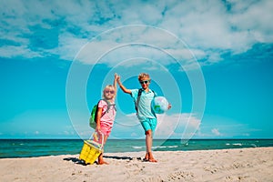 Kids travel on beach, boy and girls with backpack, globe and toys at sea