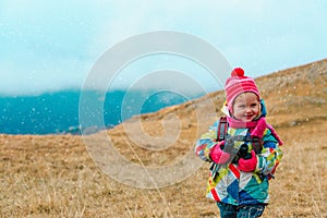 Kids travel- little girl hiking in winter mountains