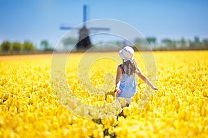 Kids in tulip flower field. Windmill in Holland