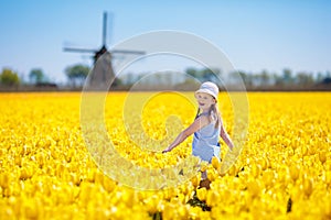 Kids in tulip flower field. Windmill in Holland