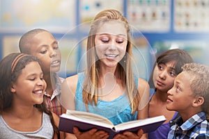 Kids, tutor and reading a book in classroom for knowledge, learning or education with happiness. Group, students or