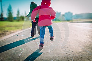 Kids- two kids- play hopscotch on playground outdoors