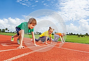 Kids in uniforms on bended knee ready to run