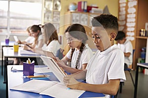 Kids use tablet computers in primary school class, close up