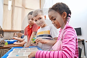 Kids using building kit to create toys.