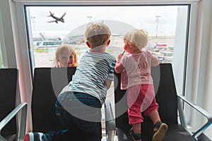 kids waiting for plane in airport, family travel concept