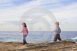 Kids walking on beach rocks