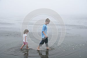 Kids walking at low tide, foggy day