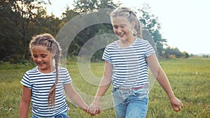 Kids walking in the park holding hands. children kid dreams happy childhood concept. two sisters are holding hands are